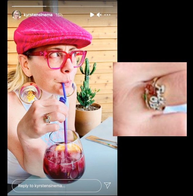 Photo of Senator Krysten Sinema drinking out of a wine glass with a straw, wearing a ring that reads "Fuck Off"
